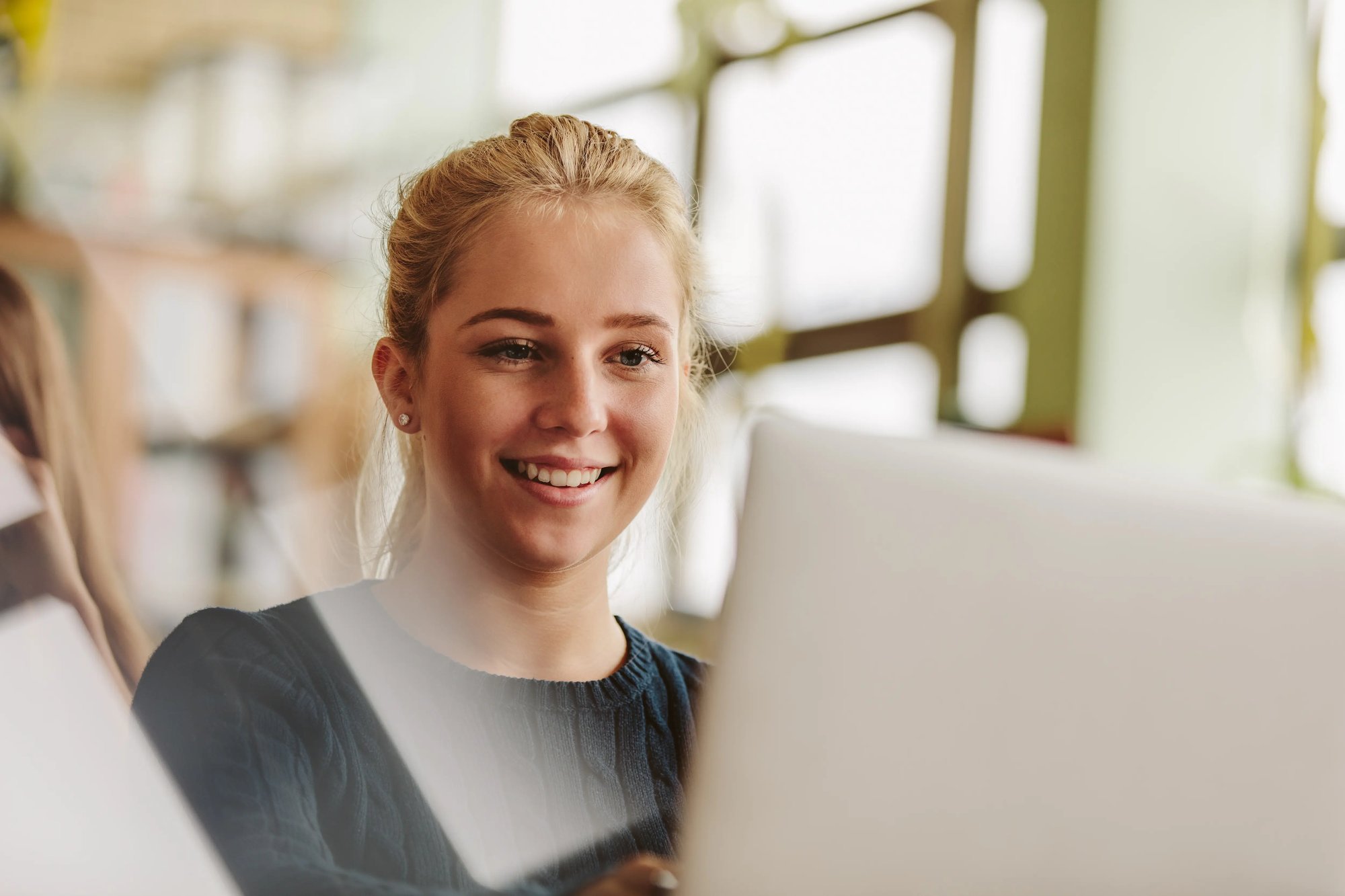 woman smiling while looking at laptop